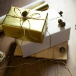 two wrapped presents sitting on top of a wooden table