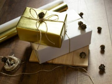 two wrapped presents sitting on top of a wooden table