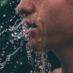 man face with water droplets