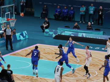 Basketball players compete on a court during a game.