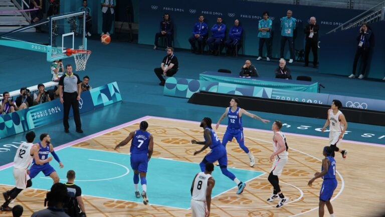 Basketball players compete on a court during a game.