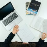 person in black long sleeve shirt holding white printer paper