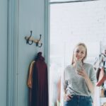 A woman takes a selfie in a dressing room.