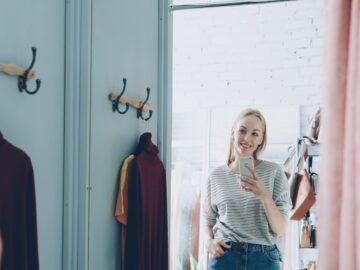 A woman takes a selfie in a dressing room.