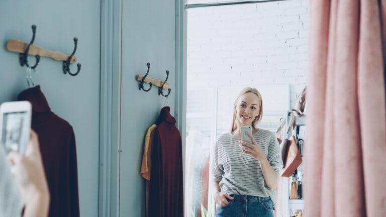 A woman takes a selfie in a dressing room.