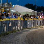 a crowd of people watching a race at night
