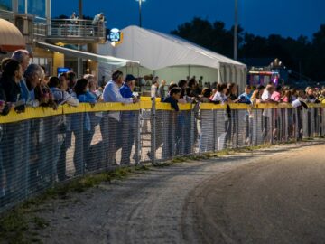 a crowd of people watching a race at night