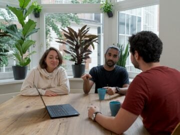 woman in white hijab sitting beside man in red crew neck t-shirt