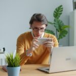 Man playing game on smartphone at desk