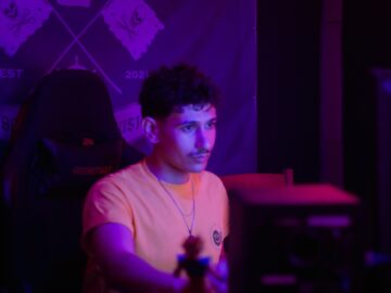 Young man in an orange shirt with purple lighting.