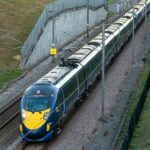 blue and yellow train on rail tracks