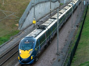 blue and yellow train on rail tracks