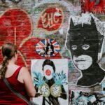 woman looking at batman graffiti wall art