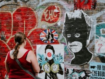 woman looking at batman graffiti wall art