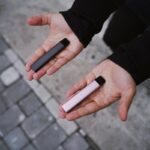 a person holding two electronic devices in their hands