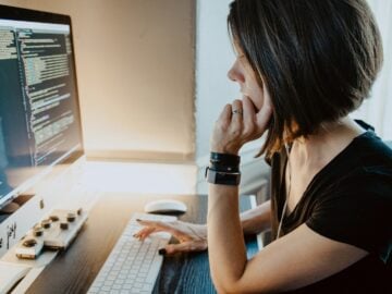 woman wearing black t-shirt holding white computer keyboard