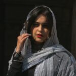 a woman in a veil smoking a cigarette