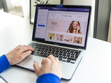 Hands typing on a laptop with an e-commerce website open, showcasing online shopping.