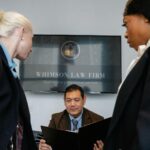 Diverse colleagues gathering in conference hall of law firm and discussing details of contract while working together