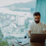 Man working on laptop with city view