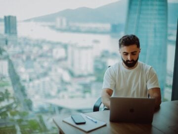 Man working on laptop with city view