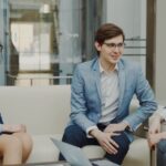 Three business people in a meeting on a couch.