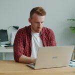 Man working on a laptop at a desk.
