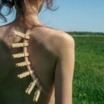 Clothespins attached to a bare back in a field.