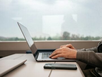 a man sitting at a desk using a laptop computer