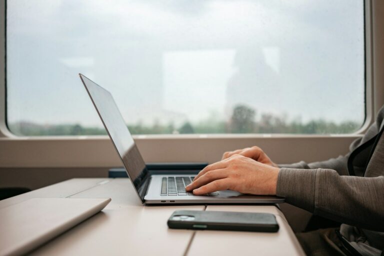 a man sitting at a desk using a laptop computer