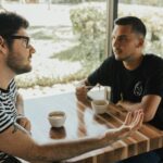 two men having conversation on table