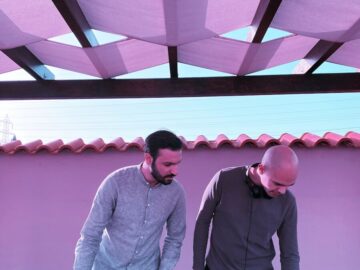 man in gray sweater and black pants standing beside man in gray sweater