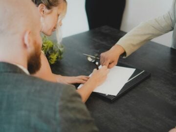 couple signing document at desk