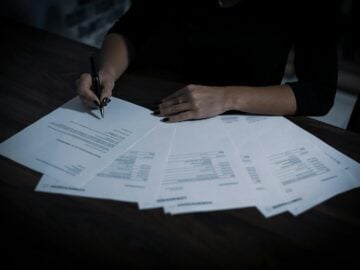 a woman sitting at a table with lots of papers