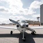 A small airplane parked in front of a hangar
