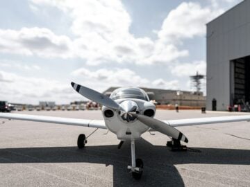 A small airplane parked in front of a hangar