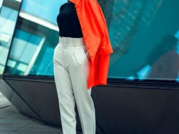 a woman standing on a sidewalk in front of a building