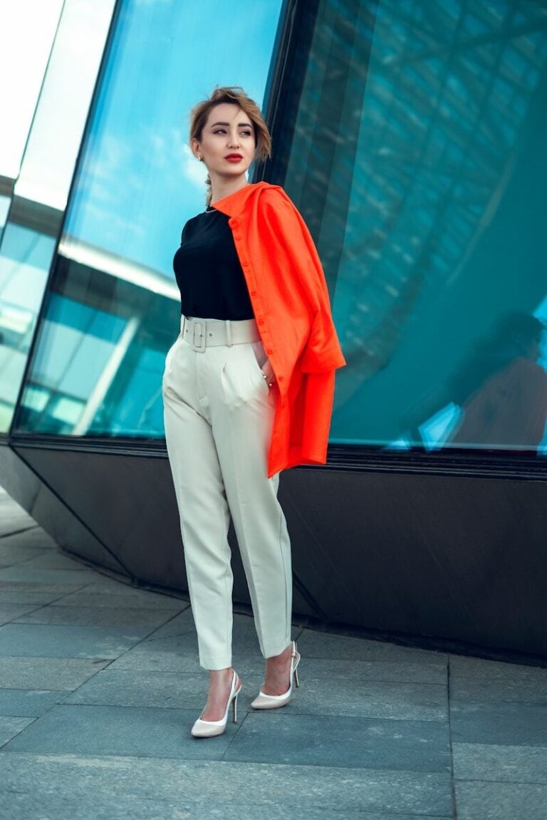 a woman standing on a sidewalk in front of a building