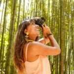 woman in yellow tank top holding black dslr camera