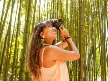 woman in yellow tank top holding black dslr camera
