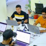 people sitting at the table using laptops