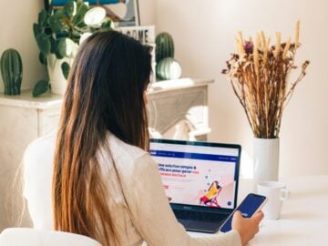 a woman sitting at a table using a laptop computer