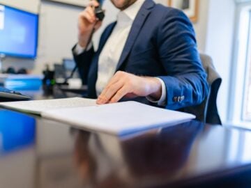 a man sitting at a desk writing on a piece of paper